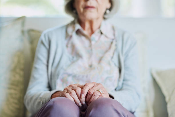 Ageing gracefully Cropped shot of a senior woman sitting on the sofa alone while in the living room of a nursing home fragility stock pictures, royalty-free photos & images