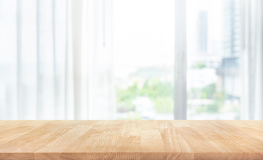 Empty of wood table top on blur of white curtain with window view background.For montage product display or design key visual layout