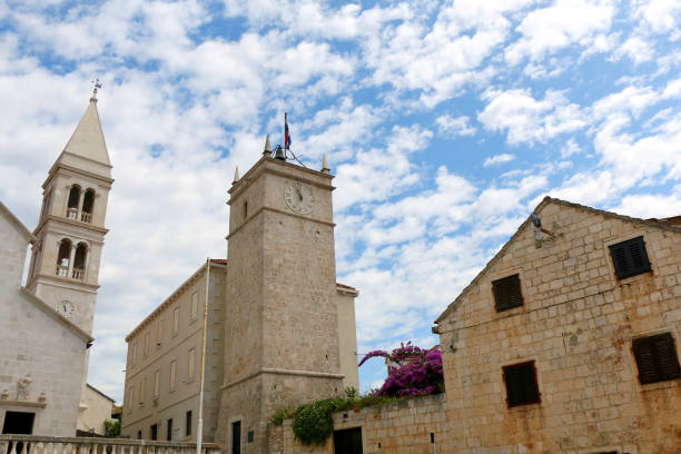 Supetar, Croatia Historic parish Church of Mary's Annunciation and clock tower Leroj in Supetar, island Brac, Croatia. old catholic church on island brac croatia stock pictures, royalty-free photos & images