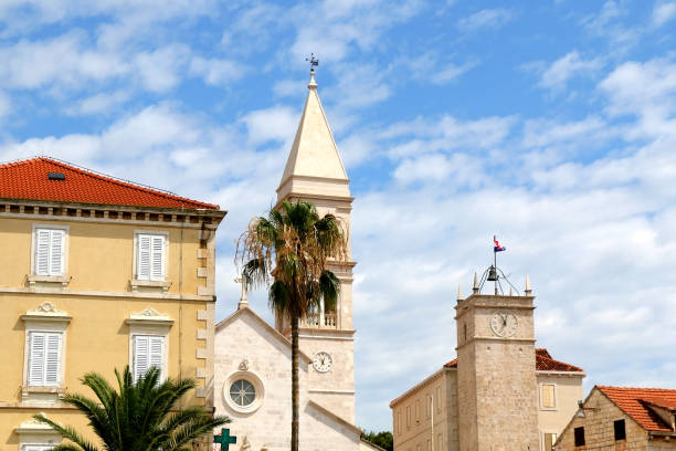 Supetar, Croatia Historic parish Church of Mary's Annunciation and clock tower Leroj in Supetar, island Brac, Croatia. old catholic church on island brac croatia stock pictures, royalty-free photos & images