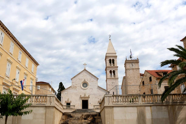 Supetar, Croatia Historic parish Church of Mary's Annunciation and clock tower Leroj in Supetar, island Brac, Croatia. old catholic church on island brac croatia stock pictures, royalty-free photos & images