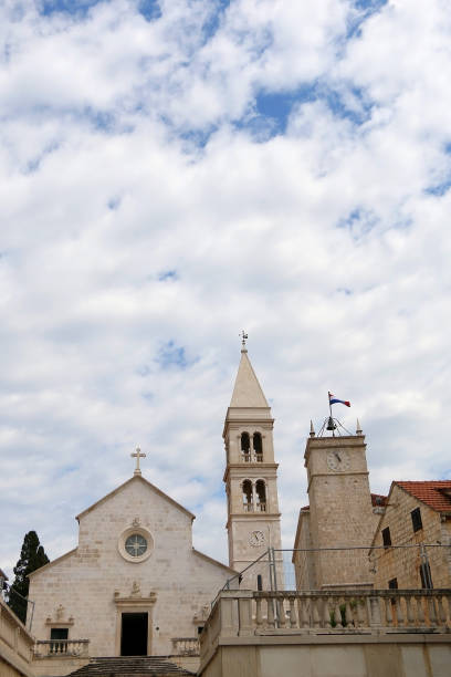 Supetar, Croatia Historic parish Church of Mary's Annunciation and clock tower Leroj in Supetar, island Brac, Croatia. old catholic church on island brac croatia stock pictures, royalty-free photos & images