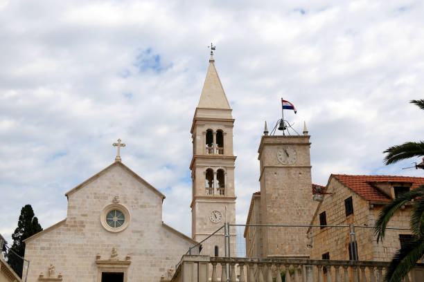Supetar, Croatia Historic parish Church of Mary's Annunciation and clock tower Leroj in Supetar, island Brac, Croatia. old catholic church on island brac croatia stock pictures, royalty-free photos & images