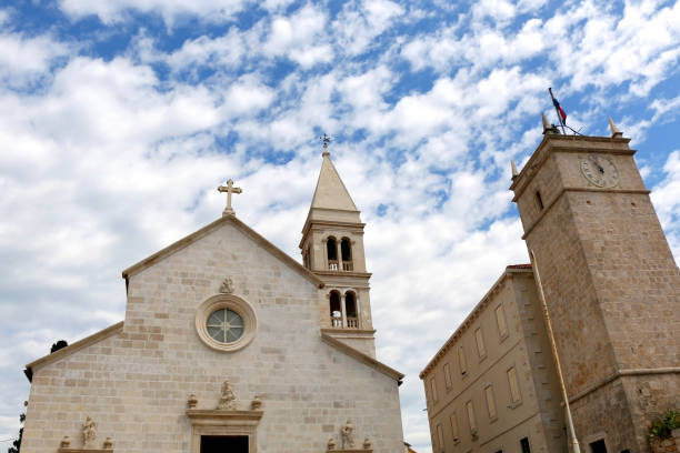 Supetar, Croatia Historic parish Church of Mary's Annunciation and clock tower Leroj in Supetar, island Brac, Croatia. old catholic church on island brac croatia stock pictures, royalty-free photos & images