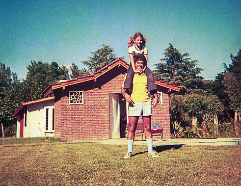 Vintage photo of a girl and her father playing outdoors