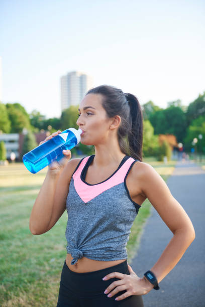 istock Young woman drinking water after hard workout 1165112944