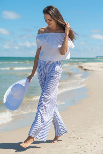 istock Beautiful woman walking by the seaside. 1165113250