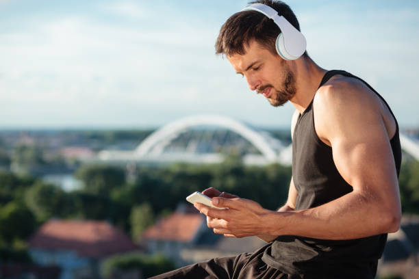istock Determined fit young man using a smart phone, listening to music after a workout 1165114218