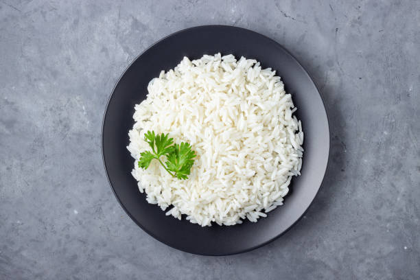 Steamed rice on black plate.