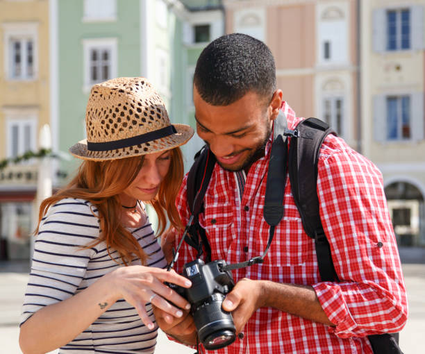 istock Mixed race couple looking at photos they took 1165120558