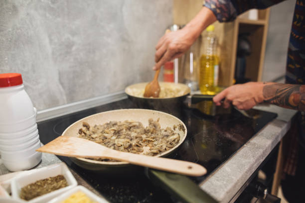 istock Man stirring ingredients together in a frying pan 1165122383