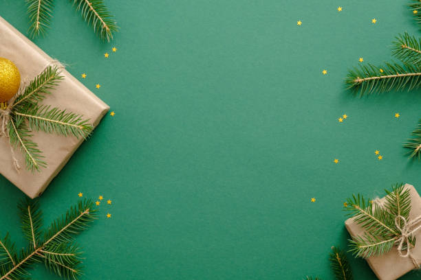 istock Christmas flatlay composition or frame with Christmas presents, fir tree branches, decoration on green background. Flat lay, top view, overhead. Xmas or New year concept. Banner mockup with copy space 1165123825