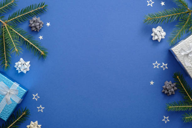 istock Christmas card concept with fir tree branches, presents, snowflakes, decorations on blue background. Christmas or New Year frame composition. Holiday and celebration mockup for postcard or invitation. 1165123908