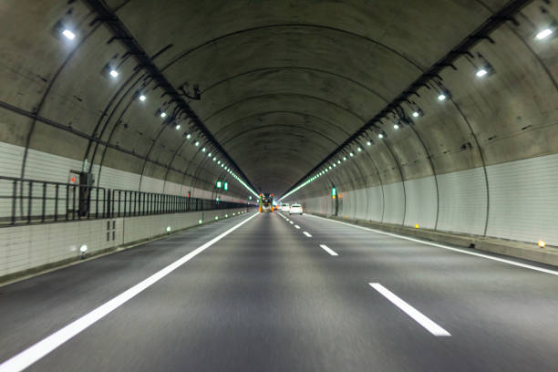 istock view of highway tunnel in mountains. 1165124010