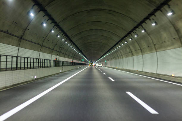 istock view of highway tunnel in mountains. 1165124040