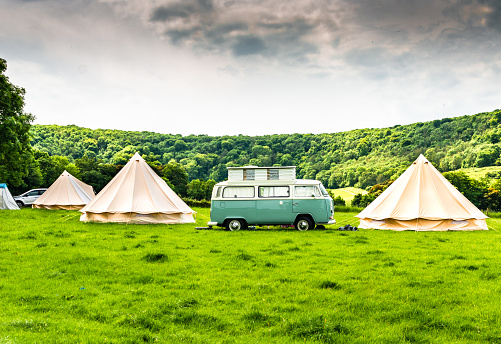 West Sussex, England - July 1, 2017: A Volkswagen Type 2 Camper​ Van and tents at a campsite by the picturesque South Downs Way