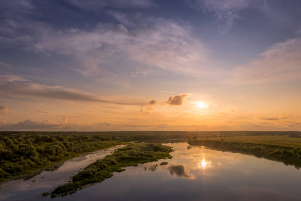 istock Aerial view to sunset on the river at summer evening with cloudy sky. 1165126228
