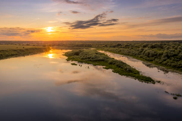 istock Aerial view to sunset on the river at summer evening with cloudy sky. 1165126232