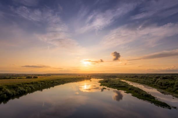 istock Aerial view to sunset on the river at summer evening with cloudy sky. 1165126233