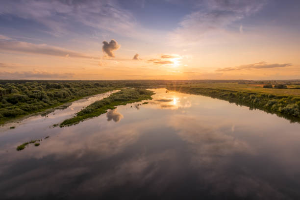 istock Aerial view to sunset on the river at summer evening with cloudy sky. 1165126235