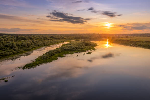 istock Aerial view to sunset on the river at summer evening with cloudy sky. 1165126252