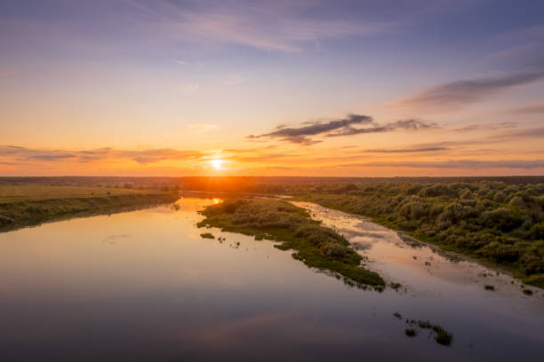 istock Aerial view to sunset on the river at summer evening with cloudy sky. 1165126269