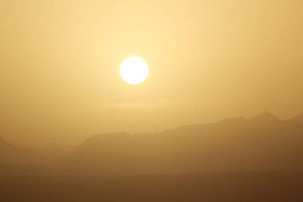 Beautiful foggy morning in sunrise time. Egyptian hills illuminated by an yellow morning sun in foggy morning.