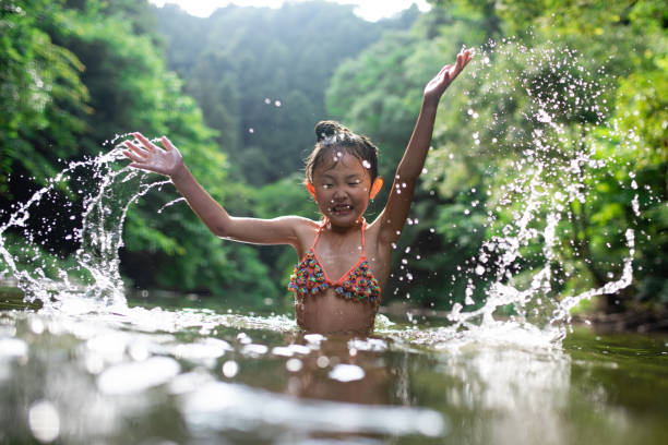 istock Girl playing in the river 1165131403