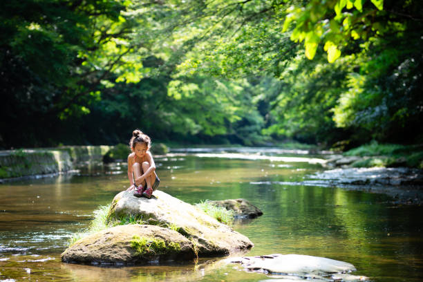 istock Girl playing in the river 1165131732