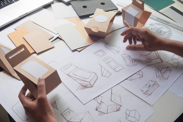 istock Designer sketching drawing design Brown craft cardboard paper product eco packaging mockup box development template package branding Label . designer studio concept . 1165132930
