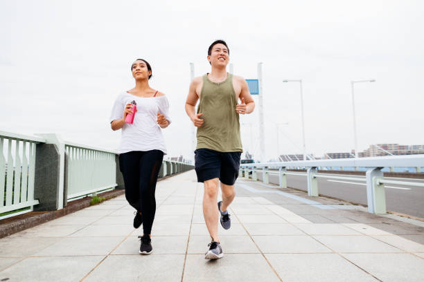 istock Multi-ethnic couple running together in city 1165135753