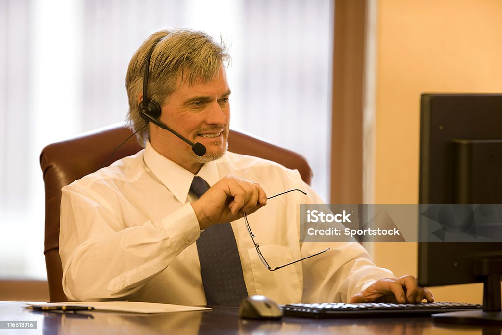Bell'uomo d'affari indossando cuffie svolgere il lavoro al Computer - Foto stock royalty-free di Abbigliamento da lavoro