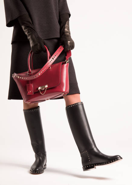 istock Girl in high black boots and a red bag. 1165139235