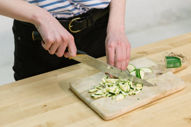 istock Young Women Cutting Chopping Courgette Zucchini on Cutting Board 1165139431