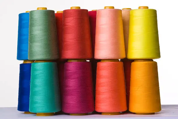 Photo of A pile of multicolored spools of sewing thread