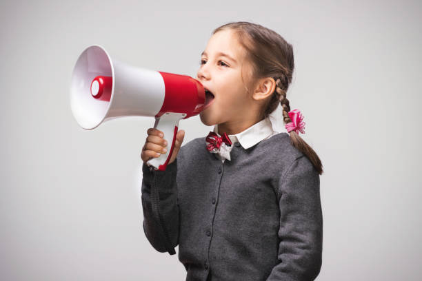 istock Child Girl Student Shouting Through Megaphone on Grey Backdrop with Available Copy Space. Back to School Concept. 1165141832