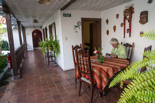 Senior men, tourist, sitting at the table on balcony of a Cuenca city hotel