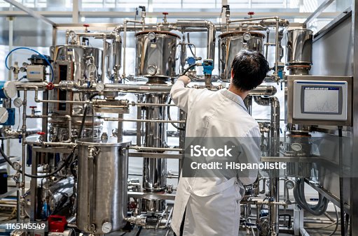 istock Back view of male student working at the process lab distilling liquids 1165145549