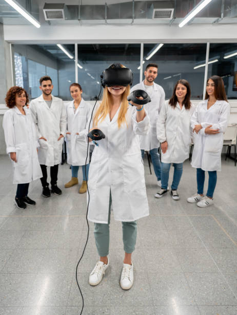 istock Happy female student trying on VR headtset during a lab design class at college 1165145641