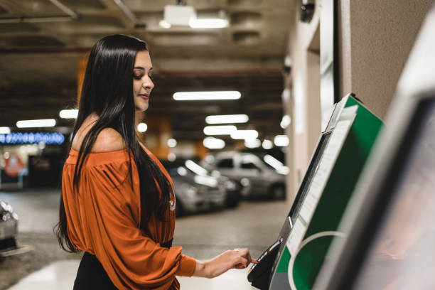 istock Woman using electronic payment at car parking 1165147035