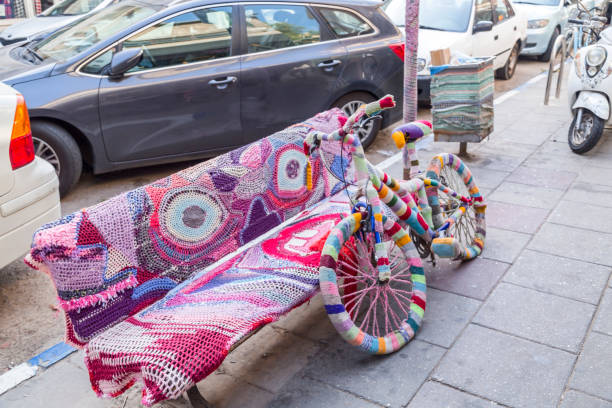 Rainbow bike decorated with colored threads, transport decorated in the hippie boho style. Beautiful bicycles no people. Decorated bike standing next to the column of the shopping center