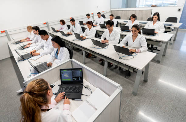 A senior professor is showing a circuit breaker to a multi racial group of  students during a technology course for adults