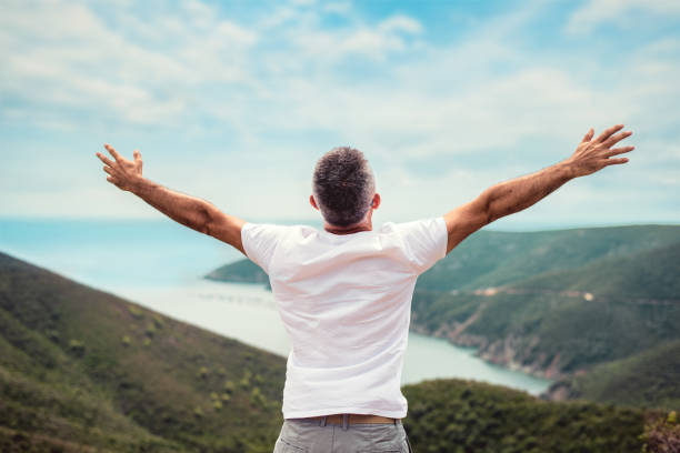 Man with arms outstretched on mountaintop