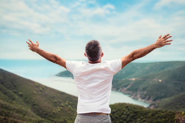 Man with arms outstretched on mountaintop Man with arms outstretched on mountaintop arms outstretched stock pictures, royalty-free photos & images