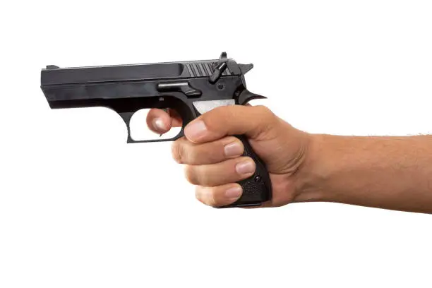Photo of Hand holding a real gun on white background