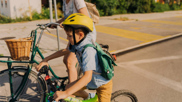 little boy commute to school with mom by bicycles - little boys preschooler back to school backpack imagens e fotografias de stock