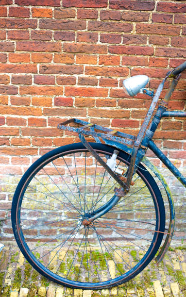 istock Amsterdam, Holland: Grotty Old Bike Parked Against Red Brick Wall 1165157684