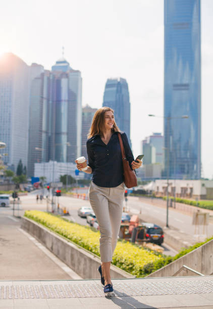 Young woman using phone and going up on stairs Hong Kong