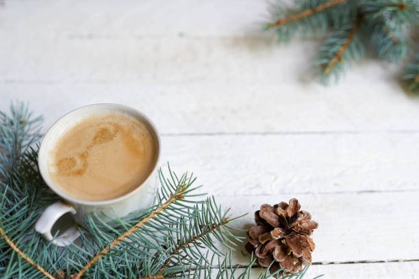 istock winter card with coffee cup and pine tree on white wooden background, copy space 1165161360