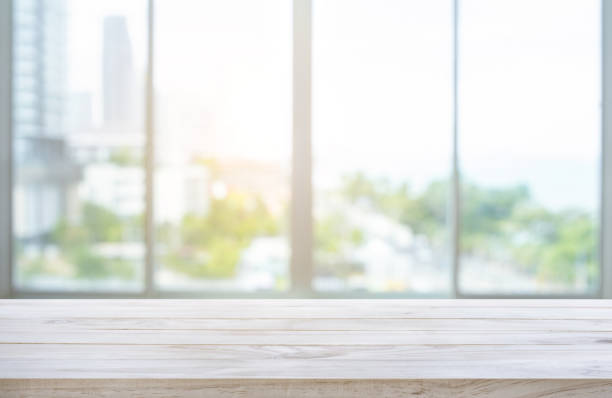 istock Wood table top on blur window glass,wall background with city view 1165165567